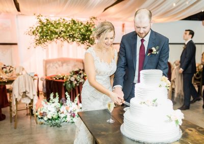 Bride and groom cutting the cake on natural wood table